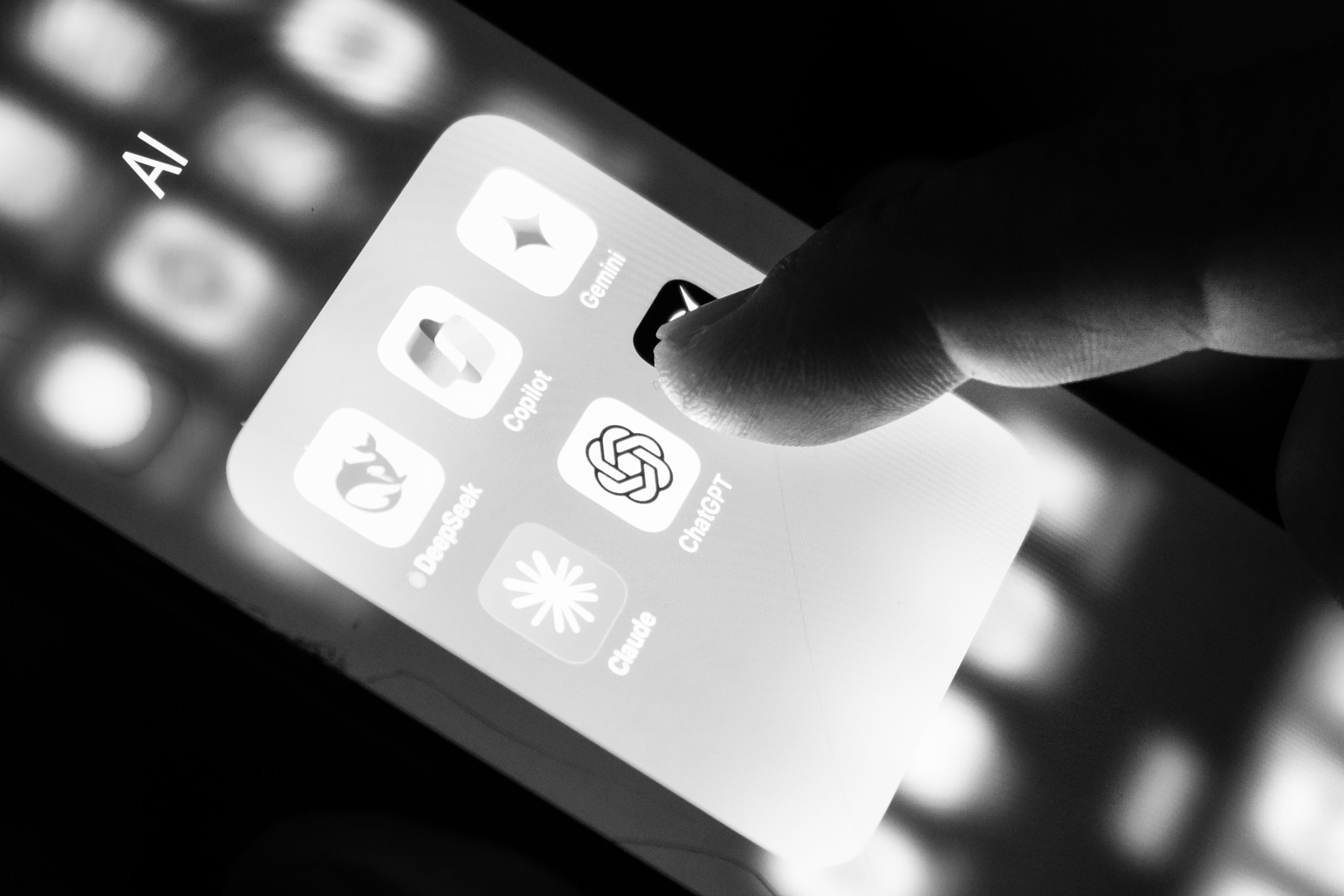 Close-up of a smartphone screen showing an AI apps folder with Gemini, Copilot, ChatGPT, Claude and DeepSeek