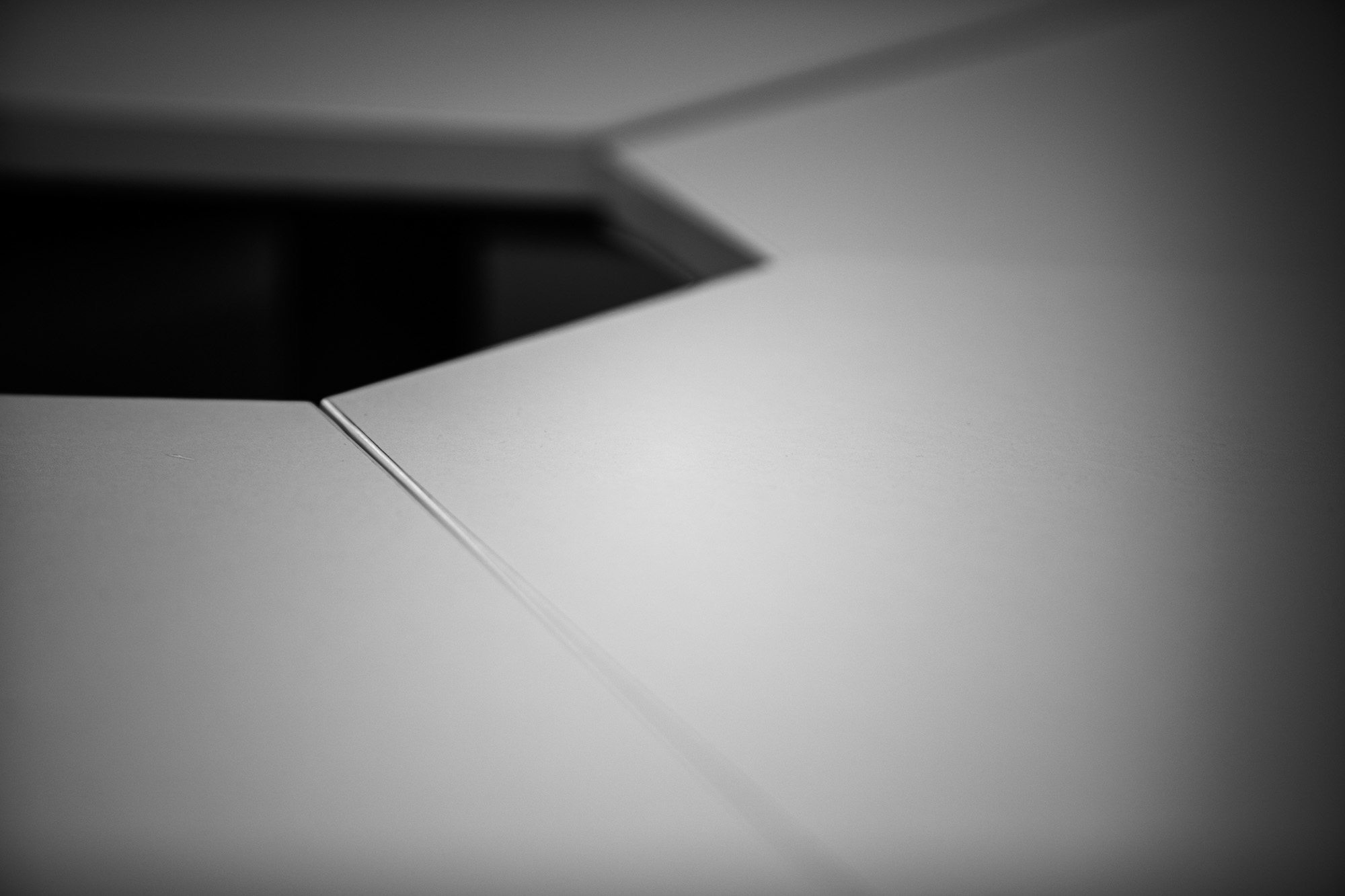 Abstract black and white geometric composition with angular white shapes creating depth and shadow