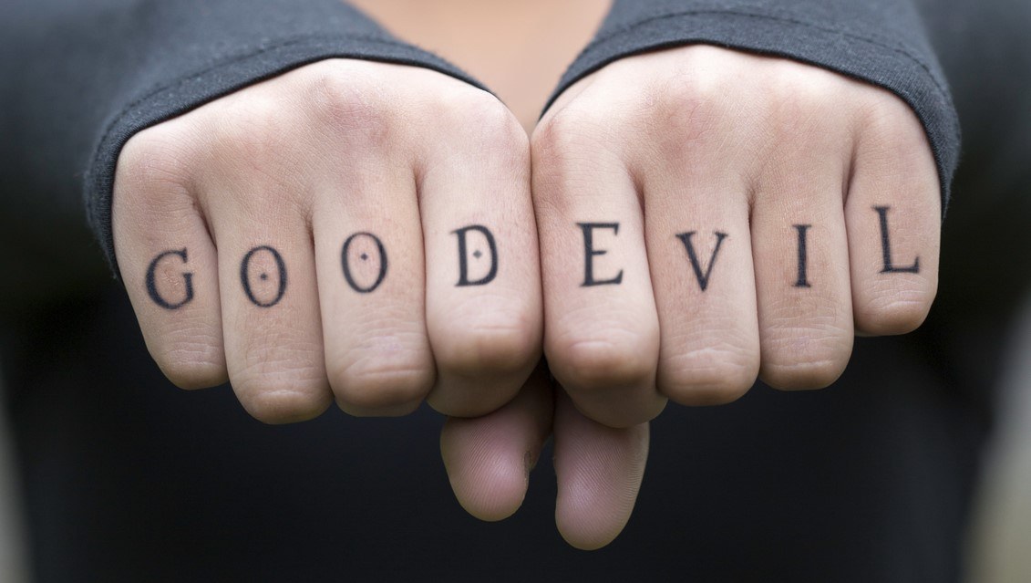 Good and evil tattooed on man’s knuckles